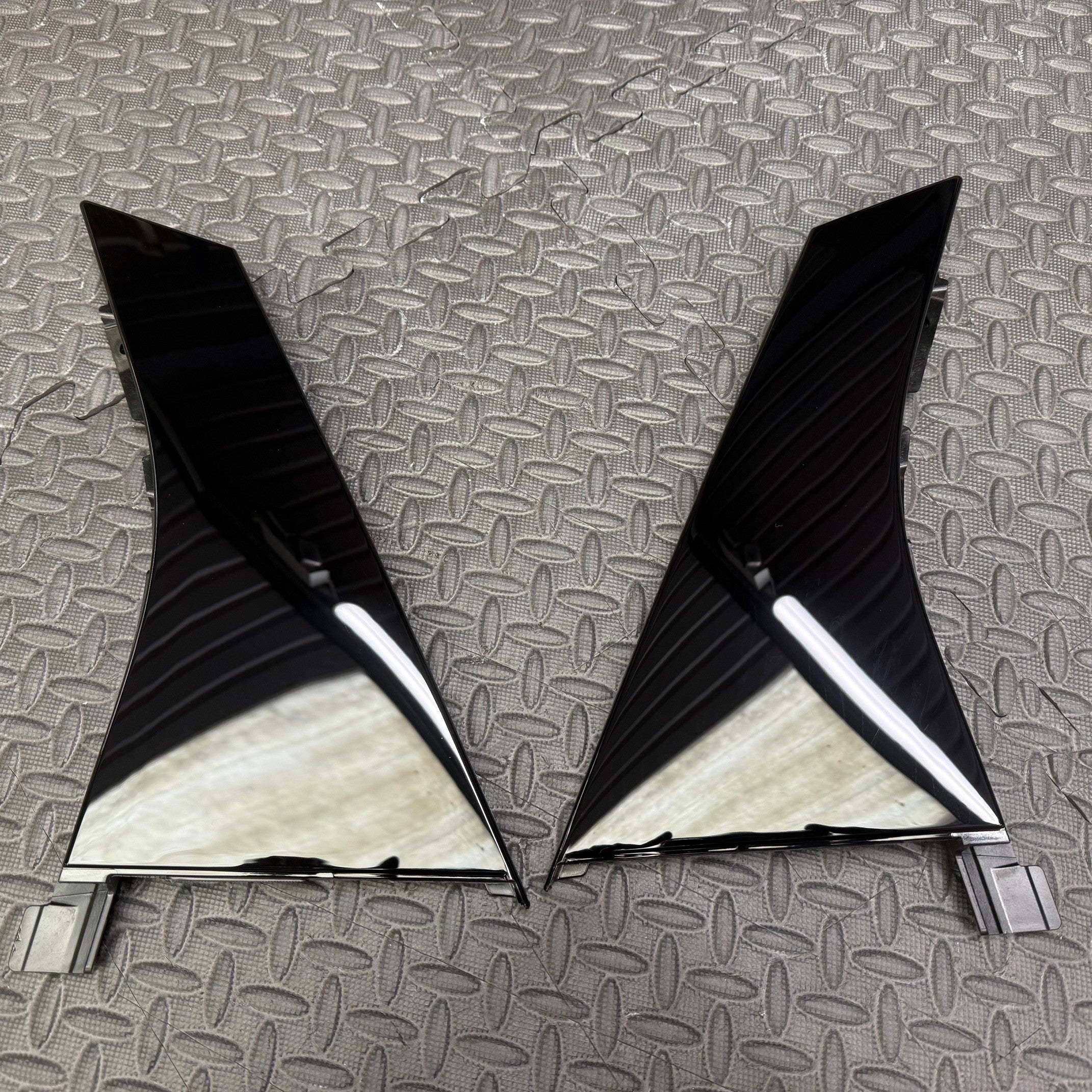 A set of two black Ford C pillar trims with a gloss black or carbon fibre finish on a textured background.