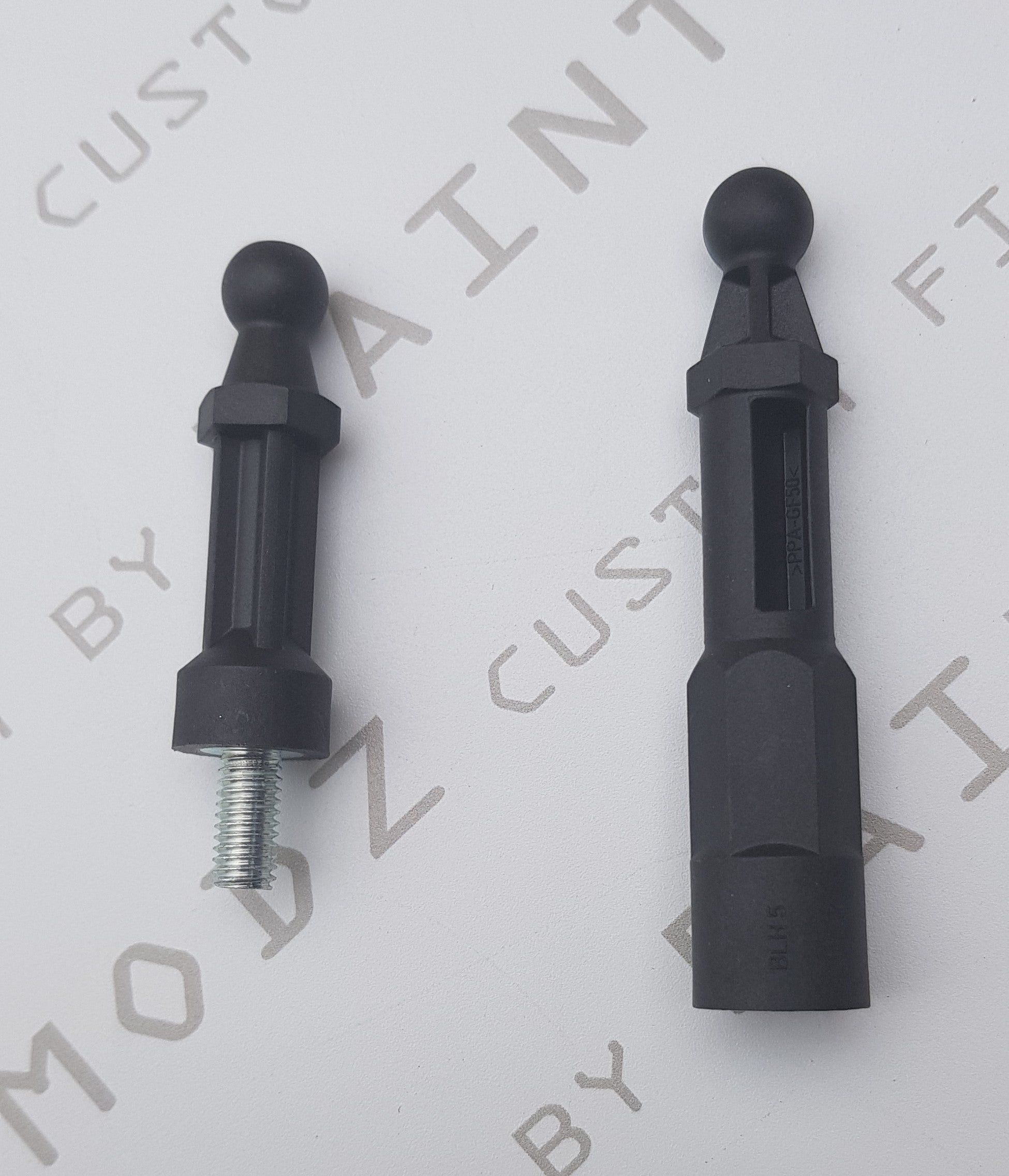 Two black Ford engine cover pegs for Fiesta Mk7.5 and Focus Mk3.5 with visible screws and threading.
