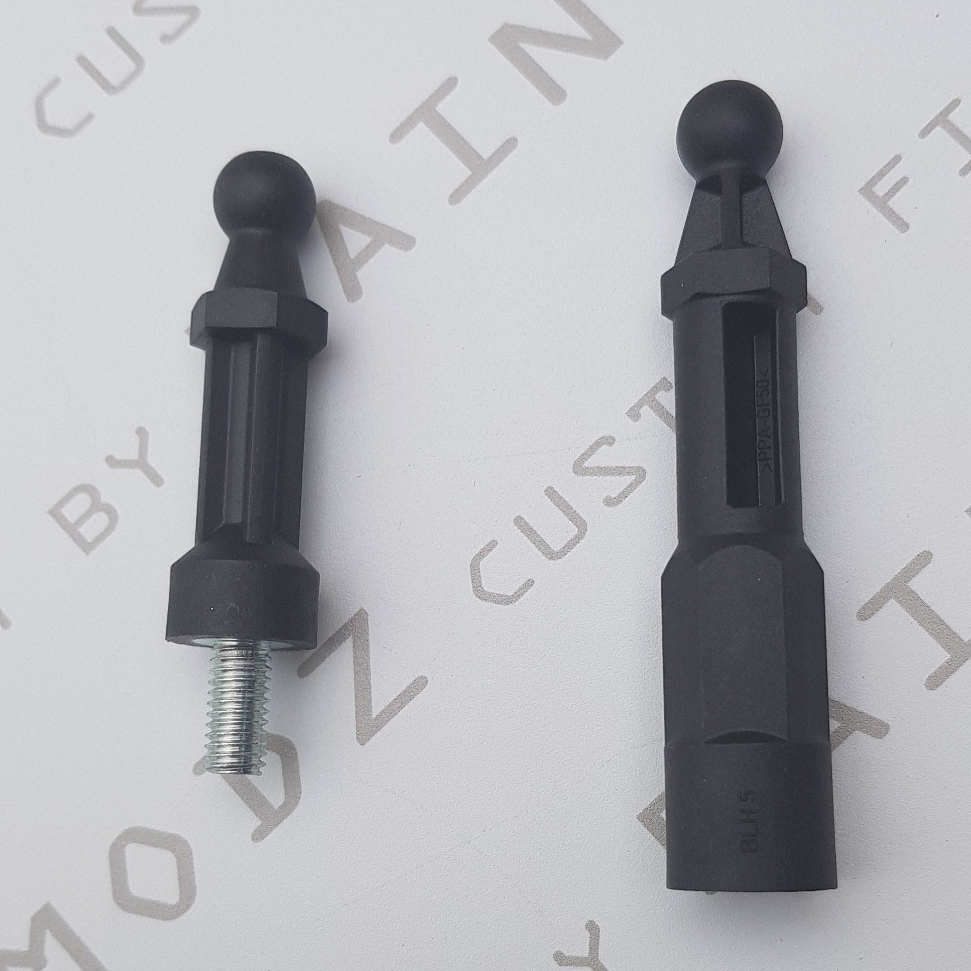 Two black Ford engine cover pegs for Fiesta Mk7.5 and Focus Mk3.5 with visible screws and threading.