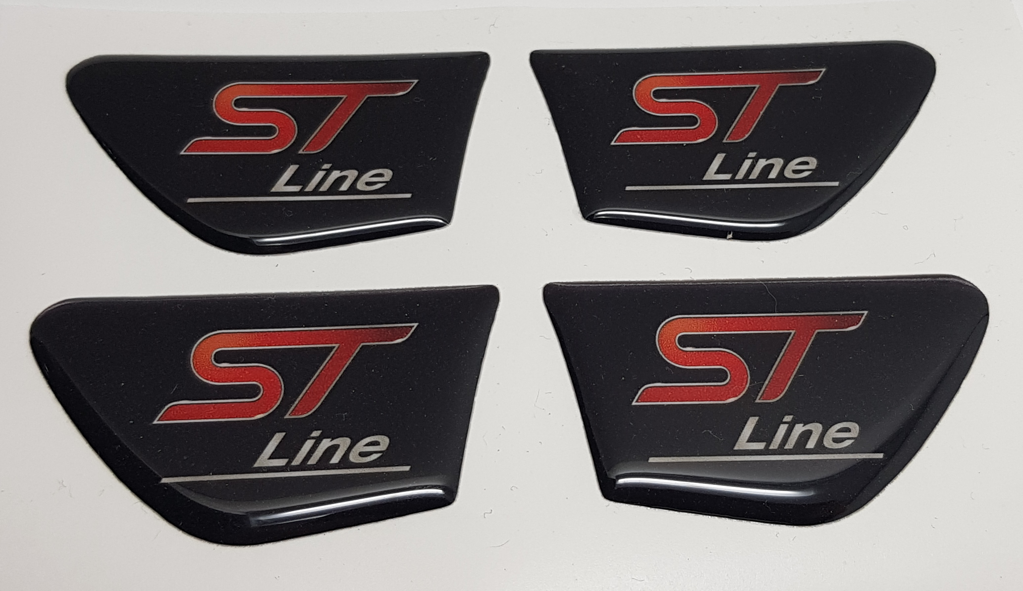 A close-up image of a custom-shaped gel badge with the 'RS' logo applied to a vehicle's interior door pull trim.