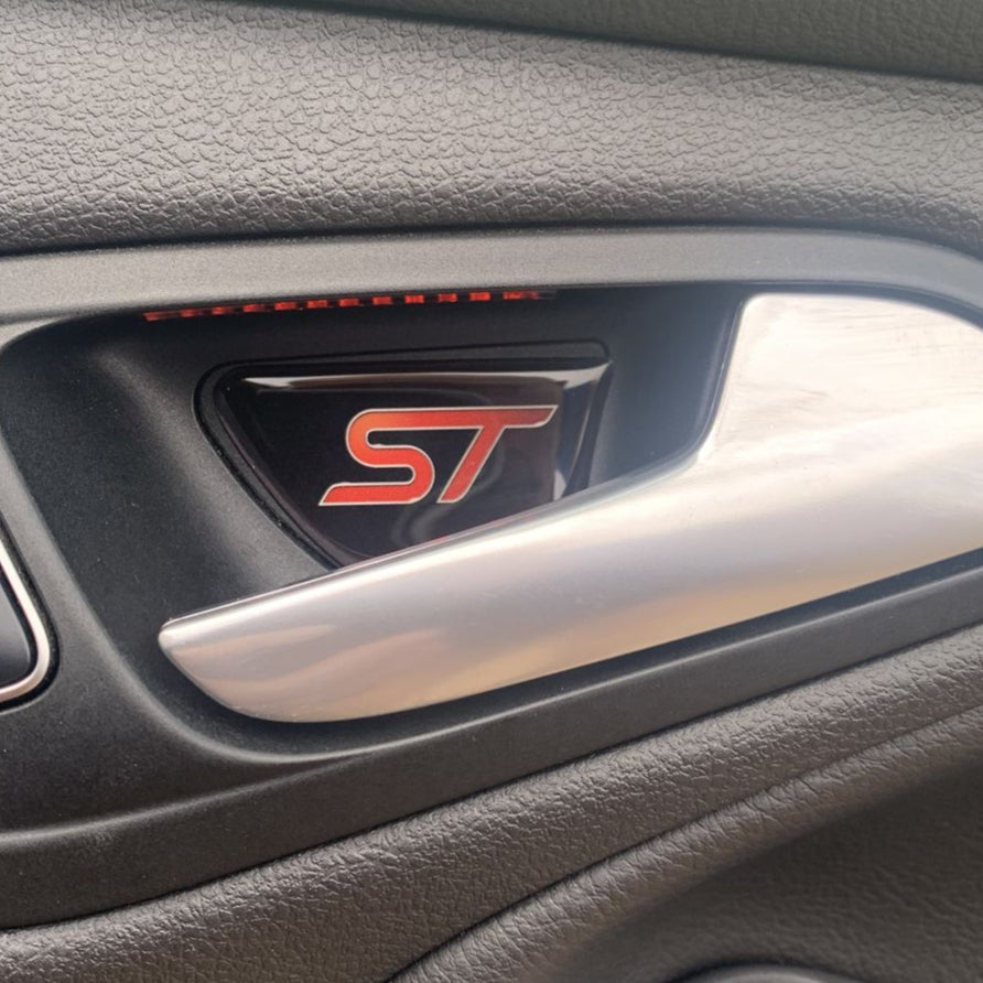 Car door handle with 'ST' logo on a vehicle interior
