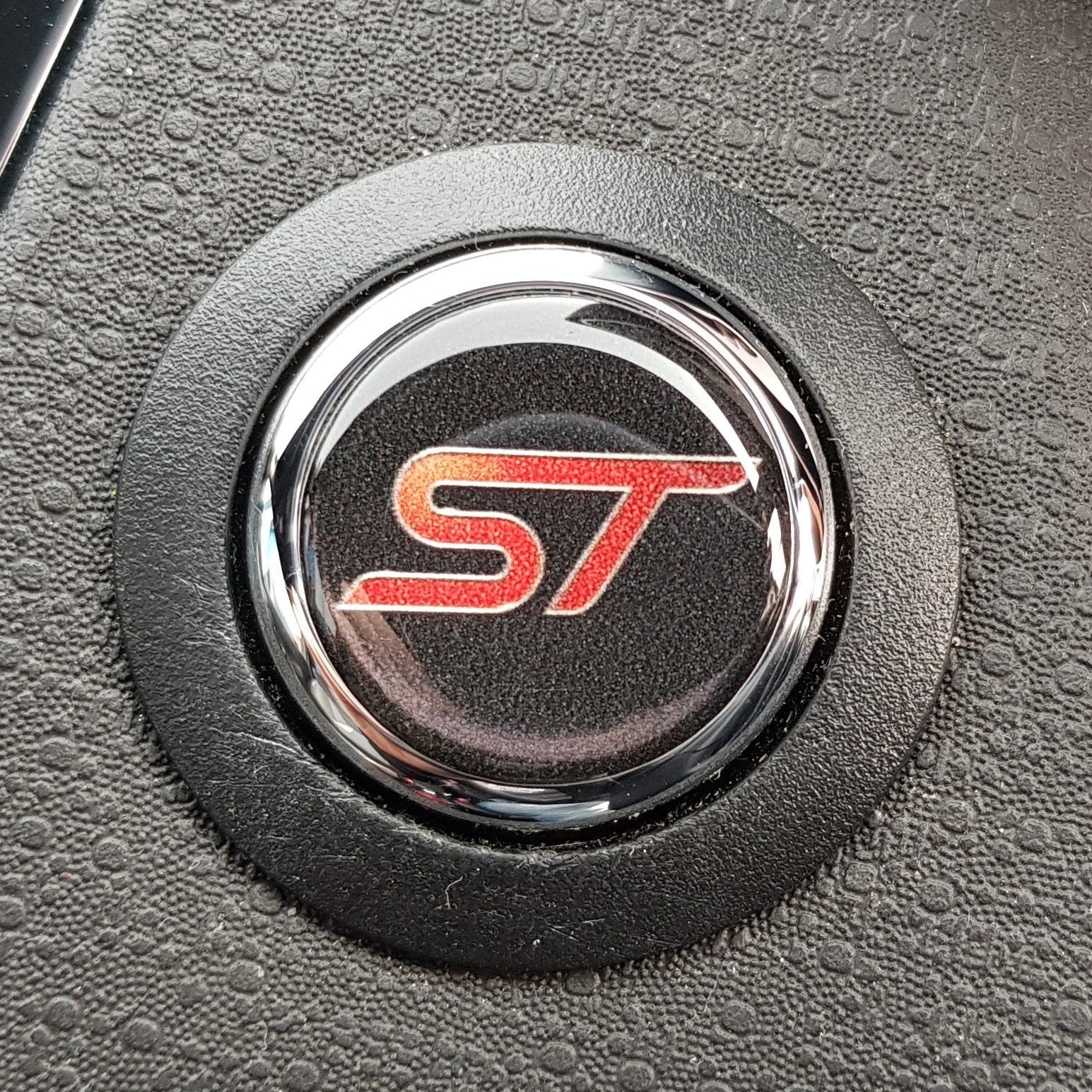 Round black gel badge with a red 'ST' logo in the center, designed to fit over a vehicle's 'Push Start' button.