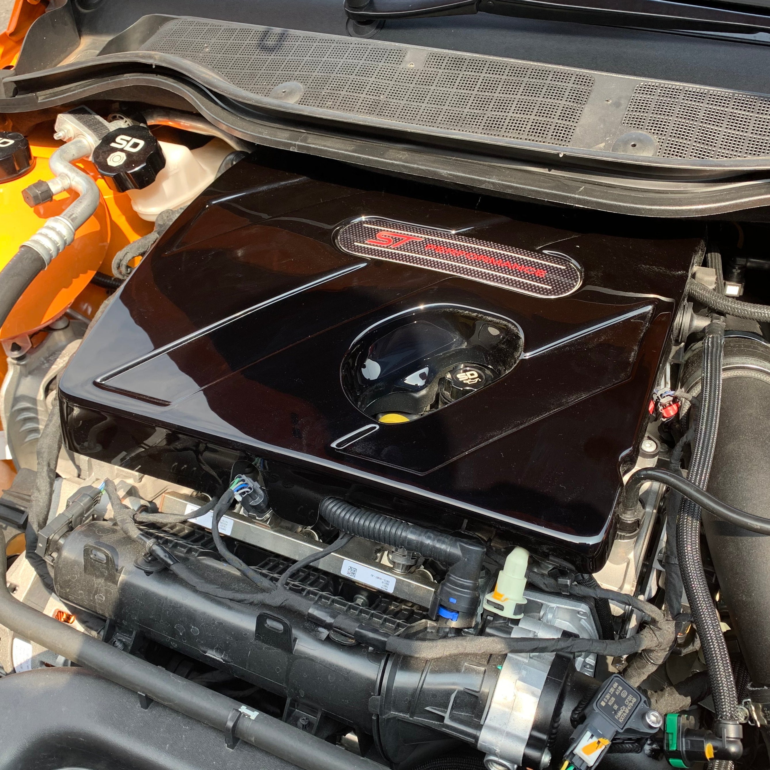 Car engine compartment with visible branding on a blurred background